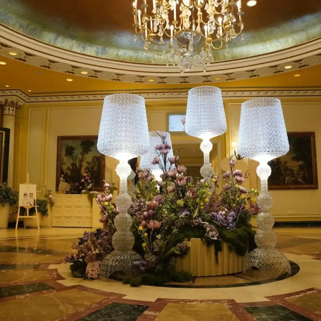 Oversized crystal lamps over lavender and pink florals in a hotel lobby