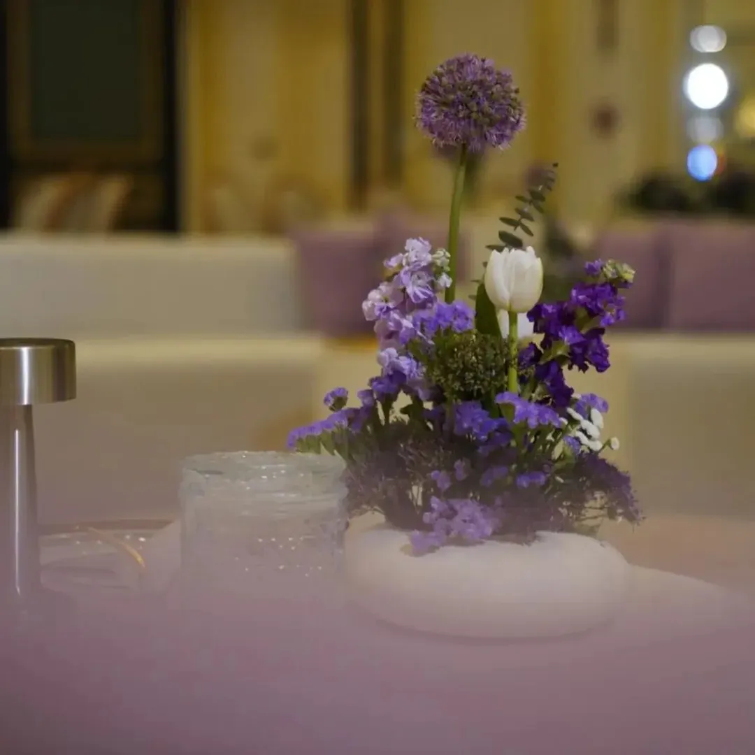 A purple and white table centrepiece in a low white vessel